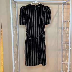 Black dress with white stripes, puffy sleeves, gold zipper, and removable belt.
